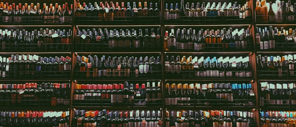 A wide variety of wine bottles on a store shelf.