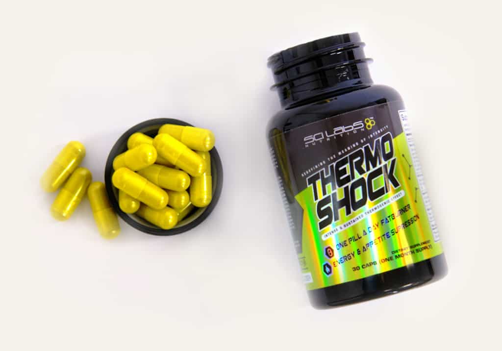 Bright yellow supplements with matching holographic label on black plastic bottle.