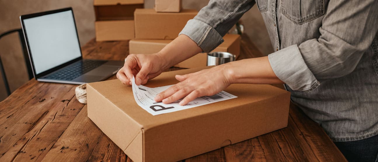 Woman applying a shipping label to a package