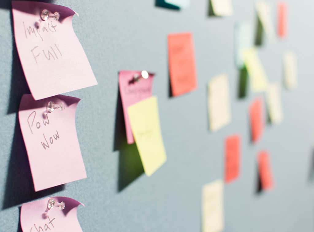 Colorful sticky notes on a wall with brainstorming notes.