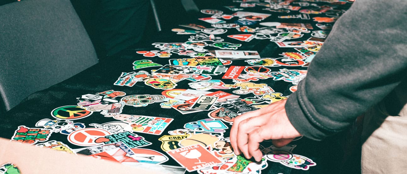 Individual perusing a table filled with a variety of die cut vinyl stickers
