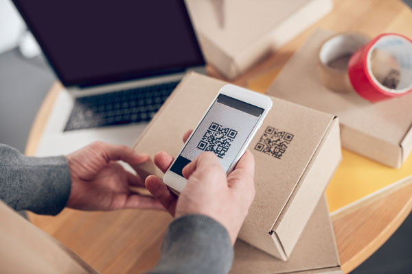person scanning smart packaging qr code on outside of box