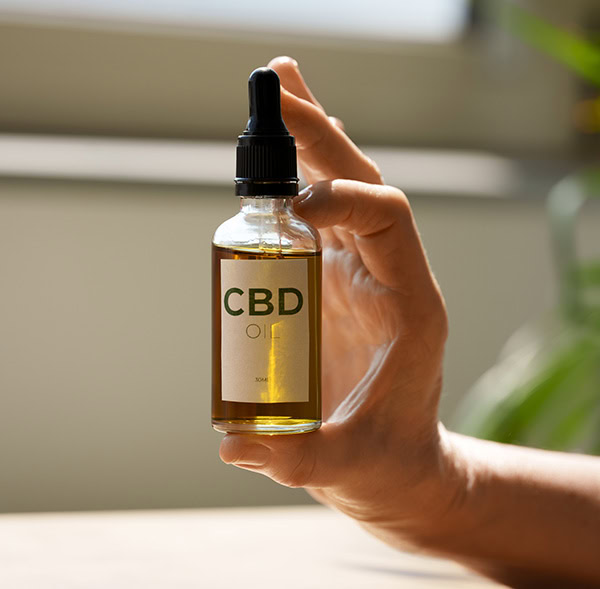 woman holding a bottle of CBD oil with label