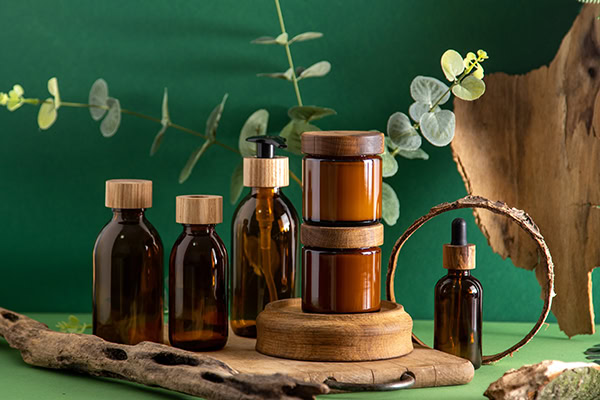 brown glass packaging containers with wood and greenery