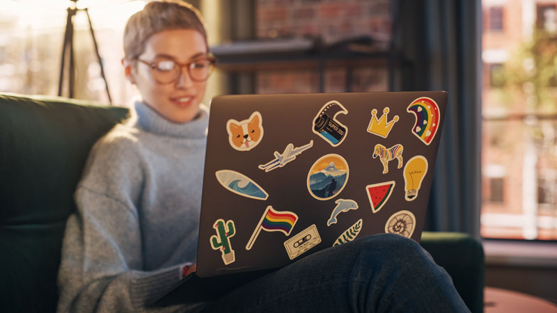 woman on laptop with die cut stickers on the back